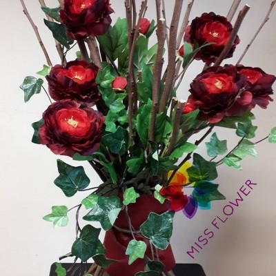 Arranjo decorativo com flores e folhas artificiais em vaso vermelho