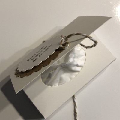 Etiqueta em papel pendurada em corda rústica sobre superfície branca