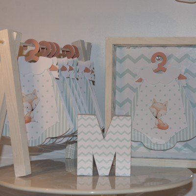 Decoração infantil com números de madeira e ilustrações de raposa em tons pastel