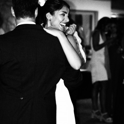 Casal a dançar com vestido branco e fato preto em ambiente interior