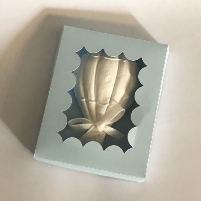 Caixa azul clara com janela decorativa mostrando um laço de fita bege.