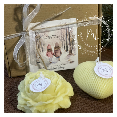 Conjunto com caixa de presente, cartão decorativo e duas velas amarelas com etiquetas.