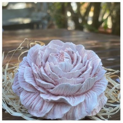 Flor branca com detalhes rosa em cerâmica sobre papel palha