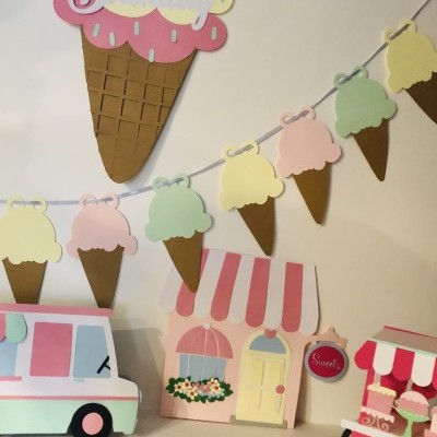 Decoração de festa com temas de gelados e lojas em papel colorido