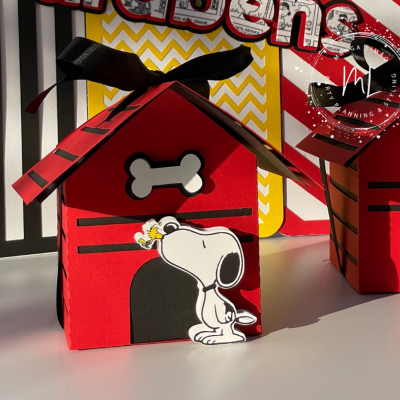 Caixa vermelha em forma de casinha de cachorro com Snoopy e osso branco.