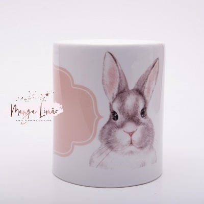Caneca branca com desenho de coelho e mancha rosa ao fundo