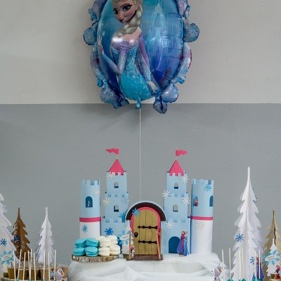 Decoração festa temática castelo azul com doces e balão Elsa.