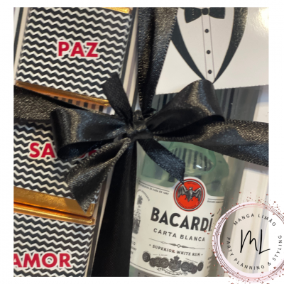 Embalagem decorativa com fita preta, garrafa miniatura Bacardí Carta Blanca e caixas com texto PAZ, SA, AMOR
