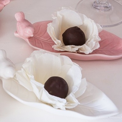 Pratos decorativos em forma de folha com pássaros e bombons dentro de flores brancas de papel