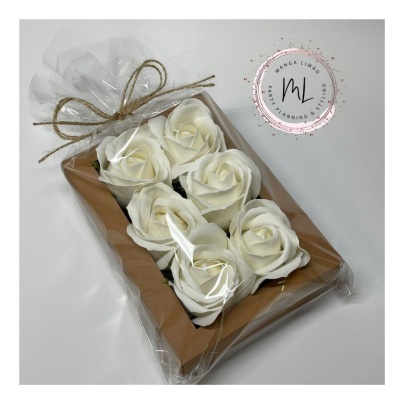 Caixa com flores brancas artificiais embalada em plástico com laço de juta
