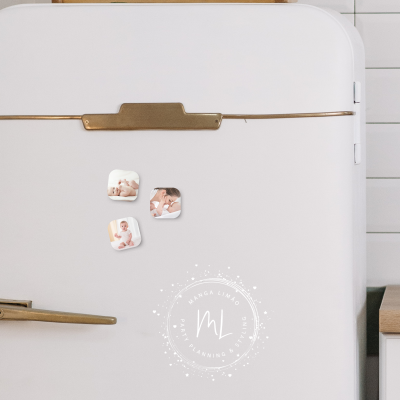 Frigorífico branco com ímanes de bebé numa cozinha moderna