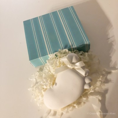 Caixa azul riscada com saco branco decorativo e enchimento branco