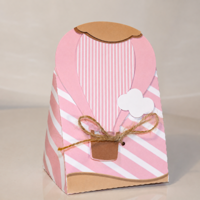 Caixa de papel rosa e branco com decoração de balão e laço