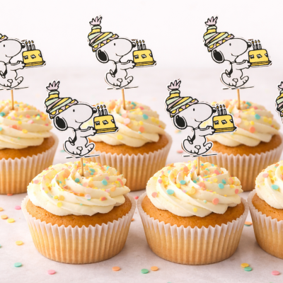 Seis cupcakes com cobertura branca e toppers da personagem Snoopy com bolo amarelo.