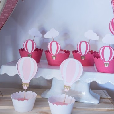Suportes para cupcakes decorados com balões de ar quente em papel, em tons de rosa e branco.