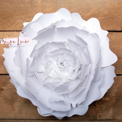 Flor decorativa grande de papel branco sobre fundo de madeira