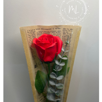 Rosa vermelha artificial com folhas em papel de jornal