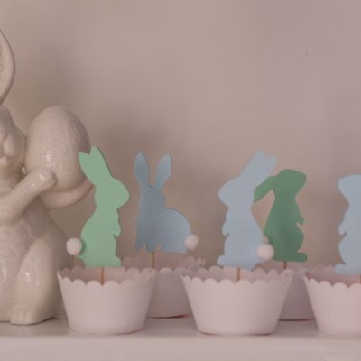 Decoração com coelho branco segurando ovo e copos com coelhinhos coloridos em papel