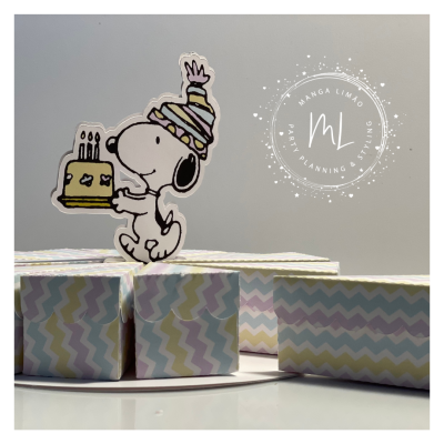 Boneco do Snoopy com bolo e chapéu de festa numa base com caixas coloridas com padrão zig-zag.