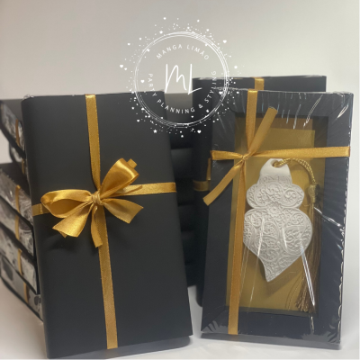 Dois produtos embalados com fita dourada, caixa preta, peça decorativa branca