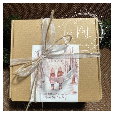 Caixa de presente com etiqueta ilustrada de crianças na neve e fita decorativa