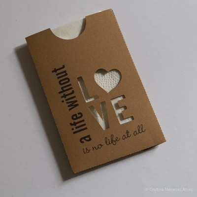 Embalagem de papelão castanho com recorte em forma de coração e letras LOVE e texto em inglês