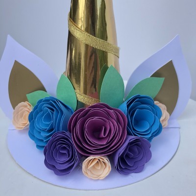 Chapéu de unicórnio com flores de papel coloridas e chifre dourado