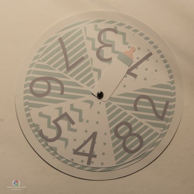 Relógio de parede redondo com padrão geométrico e números grandes