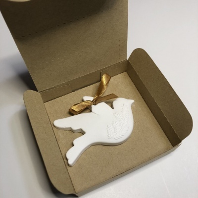 Decoração em forma de pomba branca com relevo em caixa de papelão castanho