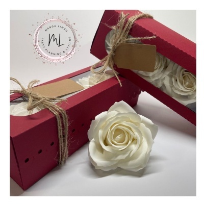 Caixas vermelhas com flores brancas artificiais e laços de corda
