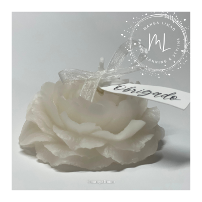 Vela branca em forma de flor com etiqueta 'obrigado'