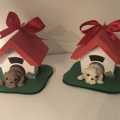 Duas casinhas decorativas com telhados vermelhos e cães pequenos à frente