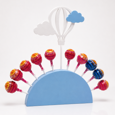 Suporte azul com pirulitos Chupa Chups e decoração de balão de ar quente e nuvens em madeira
