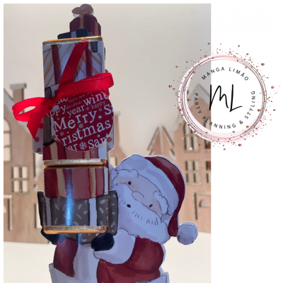 Decoração natalícia com Pai Natal e caixas com laço vermelho e texto de Natal