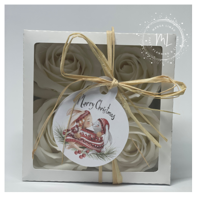 Conjunto de velas em forma de rosa embaladas com laço e etiqueta natalícia