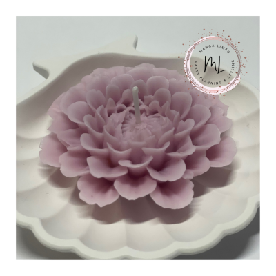 Vela rosa em forma de flor numa base branca decorativa.