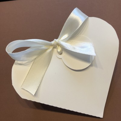 Caixa branca em forma de coração com laço de fita de cetim branca
