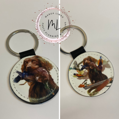 Porta-chaves de couro redondo com imagens de cão e patos em fundo branco.