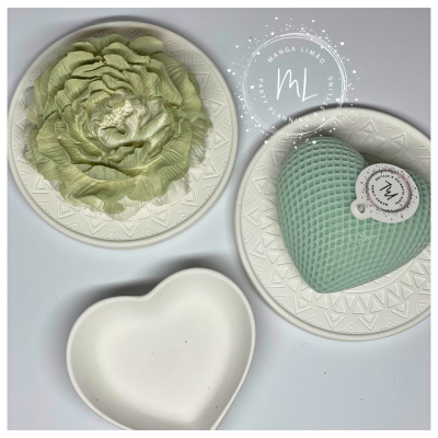 Pratos brancos decorativos com flor, vela em forma de coração e prato em forma de coração.