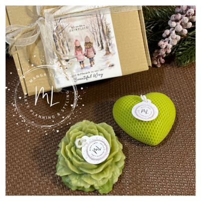 Sabonetes artesanais verdes em formas de flor e coração ao lado de caixa decorada com laço branco