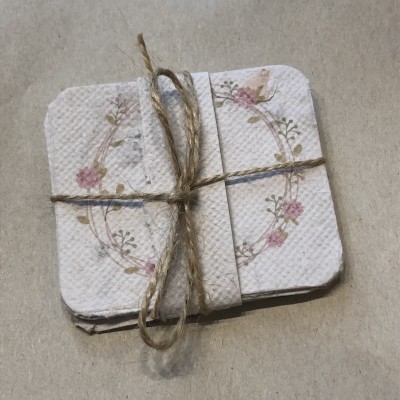 Conjunto de quatro porta-copos quadrados com padrão floral amarrados com cordão rústico