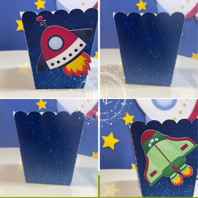 Caixas de papel azuis com desenhos de foguetes e estrelas amarelas no fundo