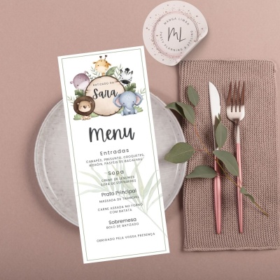 Menu decorativo com animais e talheres num guardanapo ao lado de prato.