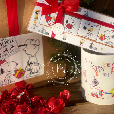 Produtos Snoopy: caixa de chocolates, caneca musical, saco de papel com desenho e chocolates embrulhados vermelhos