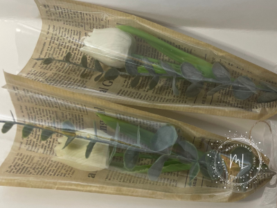 Duas flores artificiais embrulhadas em papel de jornal