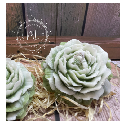 Sabonetes em forma de flores brancas e verdes sobre palha e fundo de madeira