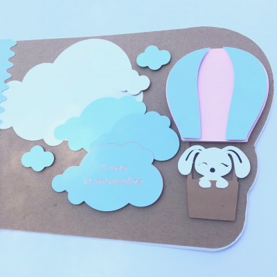 Cartão artesanal com nuvens, balão de ar quente rosa e azul e cão em cartolina