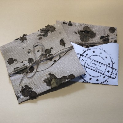 Envelopes decorativos com padrão floral em tons castanhos e cartão branco com selo preto circular
