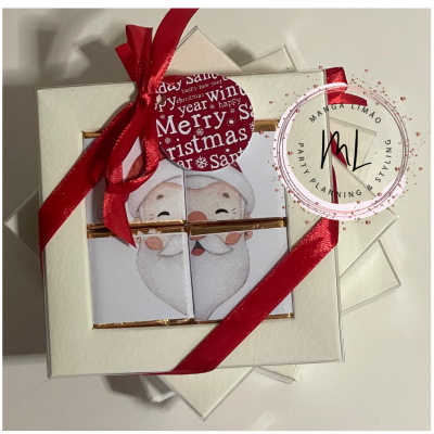 Caixa branca com chocolates decorados com rosto de Pai Natal e fita vermelha