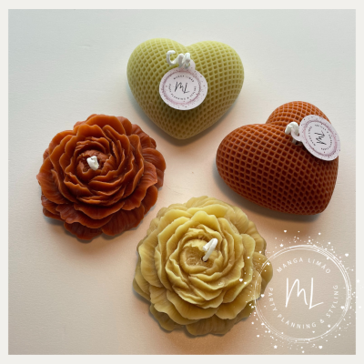 Velas decorativas em formatos de coração e flor com etiquetas redondas sobre fundo branco